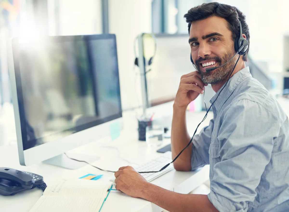 A support engineer at a desk, wearing a headset